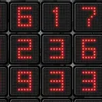 Un ecran digital afișează un aranjament de numere roșii pe un fundal negru
