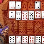 Un aranjament de cărți de joc pe un fundal modelat, cu cărți de inimă roșie, treflă, caro și pică, și pachetul de rezervă în colțul din dreapta jos
