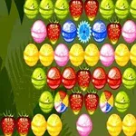 Fructe și bile colorate dispuse într-un model simetric pe un fundal verde