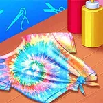 Tricou tie-dye colorat, așezat pe o masă din lemn, cu trei sticle de vopsea roșie, galbenă și albastră pe fundal albastru cu simboluri de croitorie
