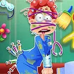 Personaj de desene animate cu păr roșcat încurcat în elastice colorate, cu o privire surprinsă, iar în jurul său se văd obiecte precum seringi, o pensulă, și foarfece