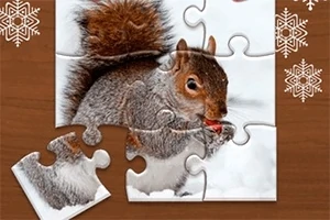 Puzzle cu o veveriță mâncând o nucă pe un fundal cu zăpadă