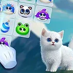 O pisică albă cu ochi albaștri stă lângă un ecran cu animale colorate într-un joc de puzzle, în timp ce o mână virtuală interacționează cu ele