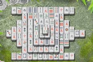 Piese de mahjong aranjate pe o masă de piatră cu un fundal de bambus verde