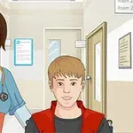 Asistentă medicală în uniformă albastră, cu stetoscop la gât, alături de un pacient tânăr într-un cărucior pe un coridor de spital