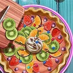 Tartă decorată cu felii de kiwi, portocale, căpșuni și frișcă, lângă un tocător cu un cuțit și kiwi tăiat pe un fundal albastru