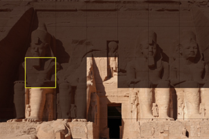 Fațada unui templu antic cu statui uriașe sculptate în piatră, cu detalii intricate