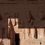 Fațada unui templu antic cu statui uriașe sculptate în piatră, cu detalii intricate