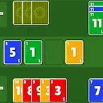 Cărți de joc colorate, numerotate, aranjate pe un fundal verde