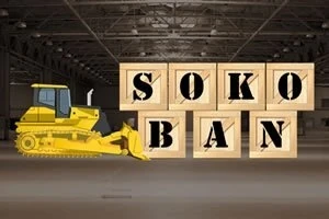 Un buldozer galben într-un depozit mută cutii de lemn inscripționate cu literele „SOKOBAN”