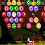 Bile colorate cu fețe de Halloween, inclusiv dovleci și capete de măgăruși, pe un fundal nocturn cu o casă întunecată
